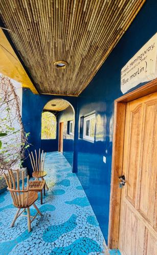 a room with blue walls and chairs and a door at Maison du Bonheur in Dakar
