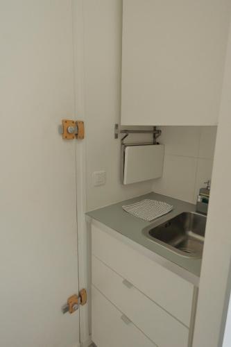 une petite cuisine avec un évier et un comptoir dans l'établissement Stay in the Heart of Paris, à Paris