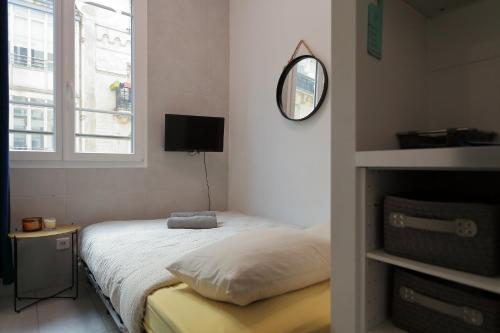 une chambre avec un lit, un miroir et une fenêtre dans l'établissement Stay in the Heart of Paris, à Paris