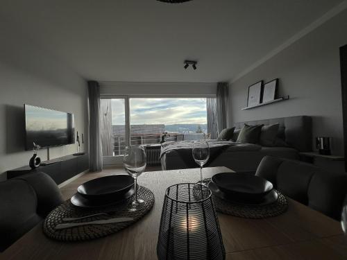 a living room with a table with two wine glasses at Black Forest Home in Schönwald