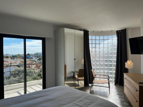 une chambre avec un lit et une grande fenêtre dans l'établissement Nice Living Hôtel Particulier Piscine, à Saint-Laurent-du-Var