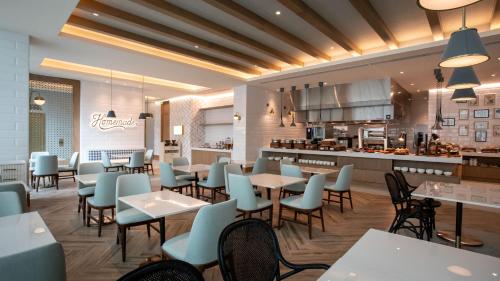 a restaurant with tables and chairs and a kitchen at Courtyard by Marriott Santo Domingo Piantini in Santo Domingo