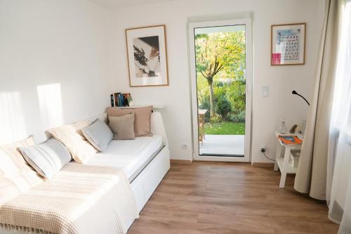 a living room with a white couch and a sliding glass door at City Apartments Gerlingen in Gerlingen