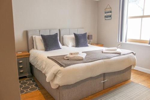 1 dormitorio con 1 cama grande y toallas. en Sandcastles 15A Fore Street, en Salcombe