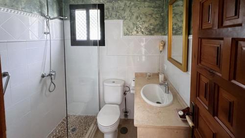 a bathroom with a toilet and a sink at Hotel Sindhura in Vejer de la Frontera