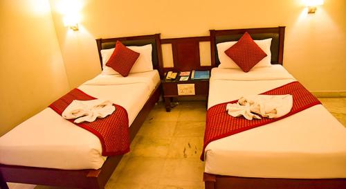 2 Betten in einem Hotelzimmer mit Handtüchern darauf in der Unterkunft Sengar's Inn in Gwalior