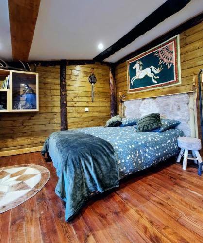 una camera con un letto in una stanza con pareti in legno di Suite privative Le seigneur des Anneaux Arnor a Vertaizon
