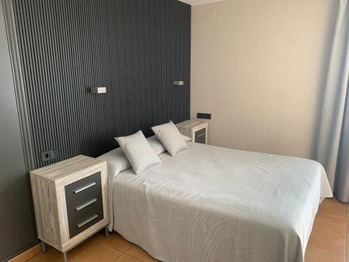 a bedroom with a white bed with two pillows at Cal Mariner in Port de la Selva
