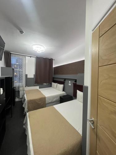 Cette chambre comprend 2 lits et une fenêtre. dans l'établissement Plaza London Hotel, à Londres