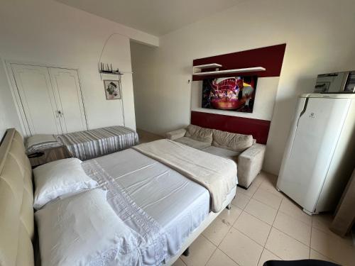 um quarto com uma cama, um sofá e um frigorífico em Apartamento Centro Manaus 721 em Manaus
