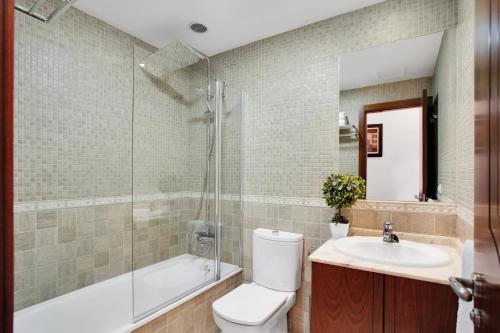 een badkamer met een toilet, een douche en een wastafel bij Villa Corralejo in Corralejo