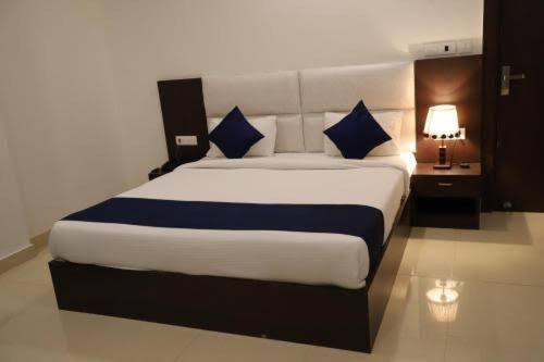a bedroom with a large bed with blue pillows at Hotel Kings Comfort in Tājganj