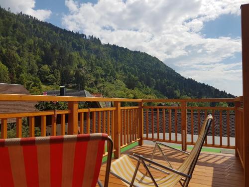 a deck with two chairs and a view of a mountain at nawu apartments & Restaurant in Hermagor