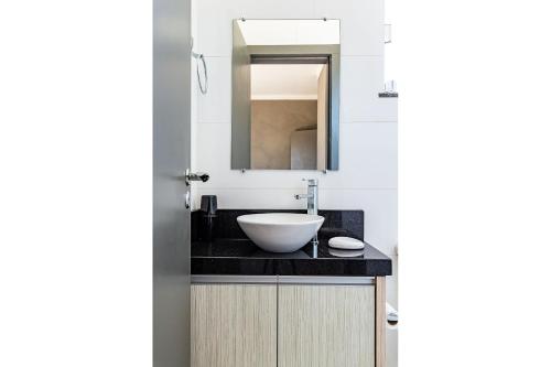 a bathroom with a sink and a mirror at Duplex pé na areia com vista deslumbrante RAT001 in Porto Belo