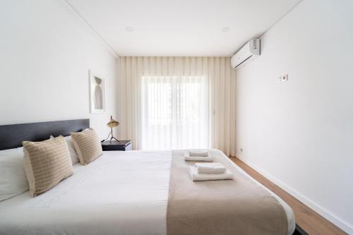 um quarto com uma cama grande com duas toalhas em António Marinho by House and People em Braga