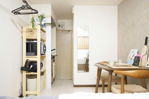a living room with a table and a kitchen at Kaku Studio Apartment Ikebukuro in Tokyo