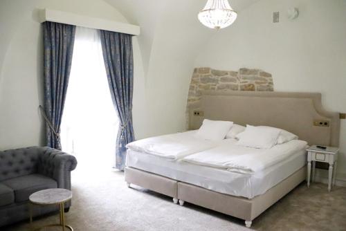 sypialnia z łóżkiem, krzesłem i żyrandolem w obiekcie Pałac w Kurozwękach w mieście Kurozwęki