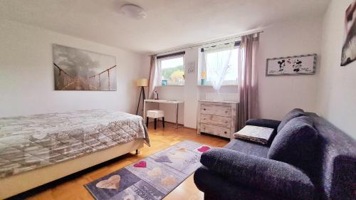 1 dormitorio con cama, sofá y escritorio en Apartment Neuweiher, en Daisendorf