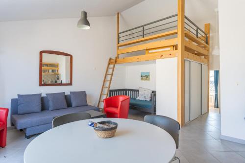 sala de estar con sofá y cama elevada en Au village f3 climatisé terrasse en Charleval