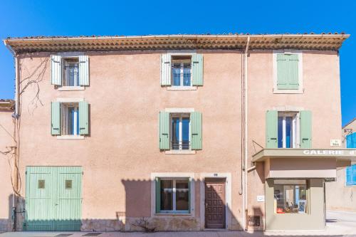 a large red brick building with green shutters at Vaste appart de 50 m2 climatisé -n5 in Charleval