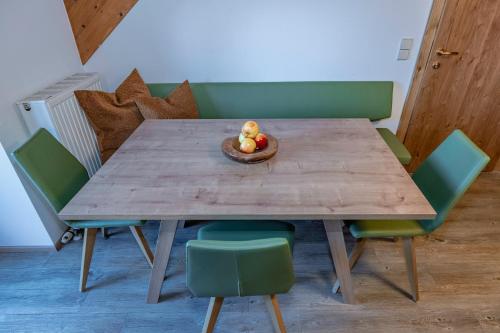 a wooden table with chairs and a bowl of fruit on it at nawu apartments & Restaurant in Hermagor