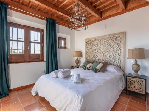 ein Schlafzimmer mit einem großen weißen Bett und einem Kronleuchter in der Unterkunft Alhambra Luxury Albaicin in Granada