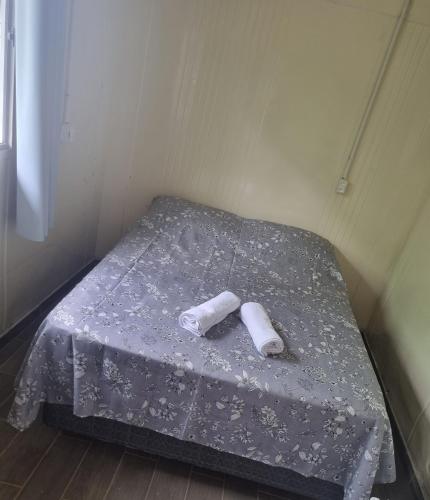 a small bed with two rolled up towels on it at Vila Verde Container BV in Barra Velha