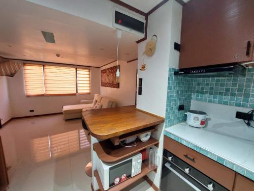a kitchen and living room with a table and a sink at Stay in Manila, Cambridge Village in Cainta