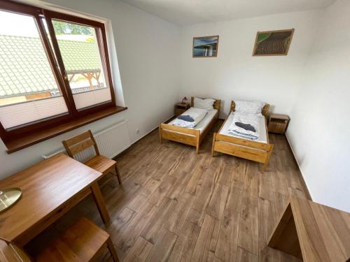a room with two beds and a table at Pokoje w Moszczenicy U Pasonia in Stary Sącz