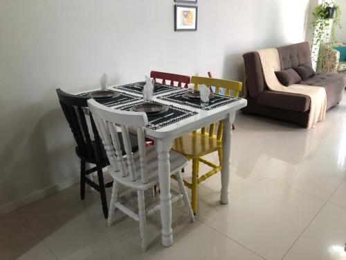 mesa de comedor con 4 sillas y sofá en A casa da Keila - Balneário Camboriú, en Balneário Camboriú