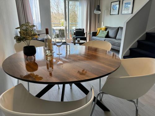 een eetkamer met een houten tafel en stoelen bij Appartement, Amelander Kaap 121 in Hollum