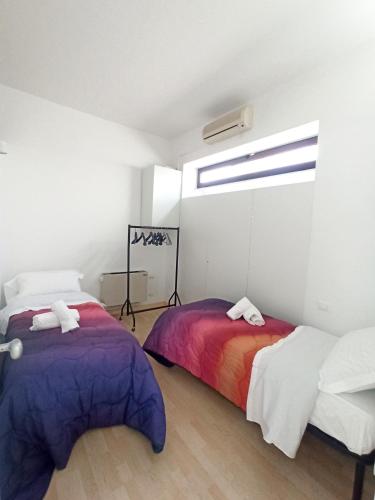 2 camas en una habitación con ventana en IL LOFT AI PILA, en Montebelluna