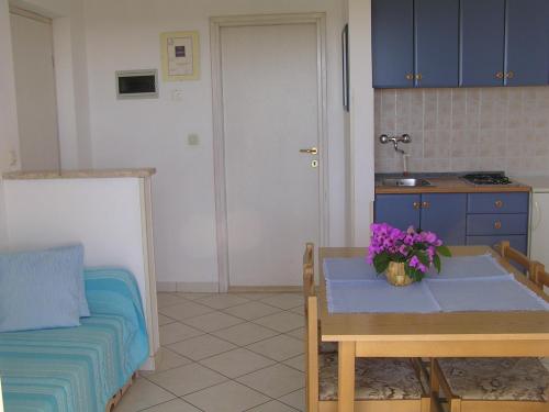 a kitchen with a table with flowers on it at Apartments Paloma blanca 1 in Medulin