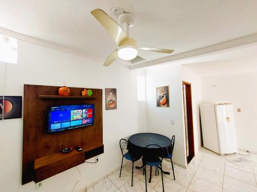d'une salle à manger avec une table et un ventilateur de plafond. dans l'établissement Kitnet Quarto Sala Cozinha com Ar Condicionado 102, à Cabo Frio