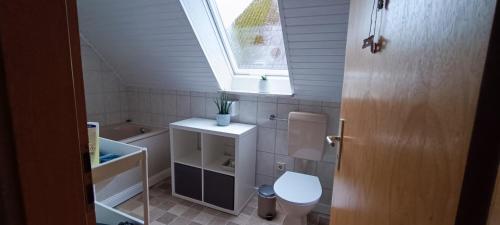 een kleine badkamer met een toilet en een raam bij Ferienwohnung KIEK IN in Hagen im Bremischen