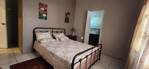 una camera da letto con un letto con cuscini sopra di Vista Stays ...Alluring Ambrosia near to Airport a Trincity 