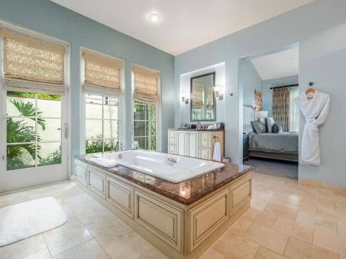 Terranea Resort في رانتشو بالوس فيرديس: حمام كبير مع حوض استحمام وغرفة نوم