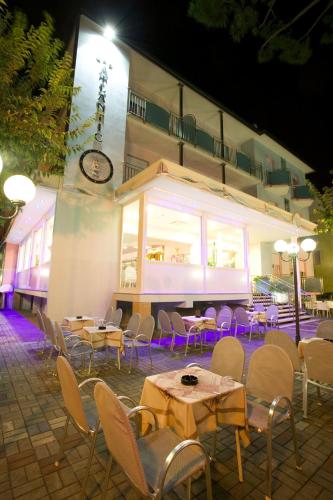 a group of tables and chairs in front of a building at Hotel Atlantic in Gatteo a Mare