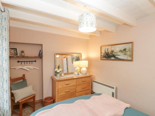 Schlafzimmer mit einem Bett, einer Kommode und einem Spiegel in der Unterkunft Rose Lea in Saltburn-by-the-Sea