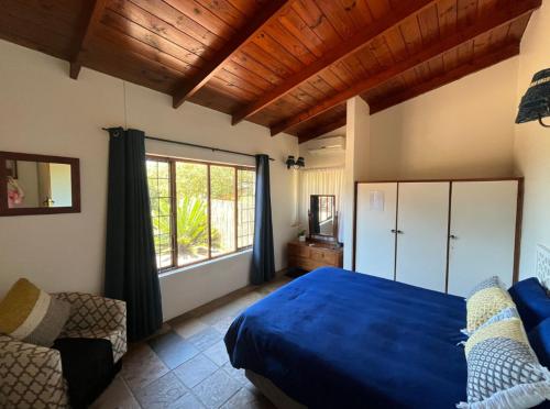 a bedroom with a blue bed and a window at Beefwood Beach House in Pennington