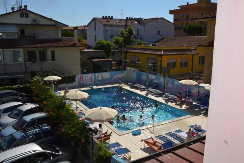 einen Blick über einen Pool mit Stühlen und Sonnenschirmen in der Unterkunft Hotel Atlantic in Gatteo a Mare