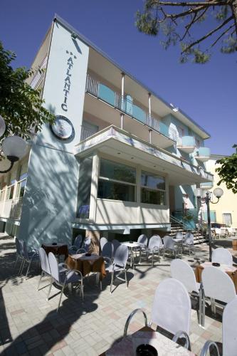 a group of chairs and tables in front of a building at Hotel Atlantic in Gatteo a Mare