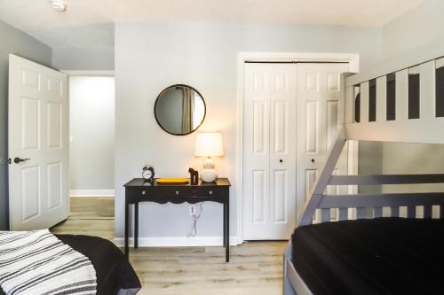 a bedroom with a bed and a table with a mirror at 5 Mi to Lake Naomi Home with Hot Tub and Fire Pit in Long Pond