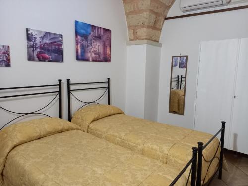 2 letti in una camera con immagini a parete di Curti Russi a Monteroni di Lecce