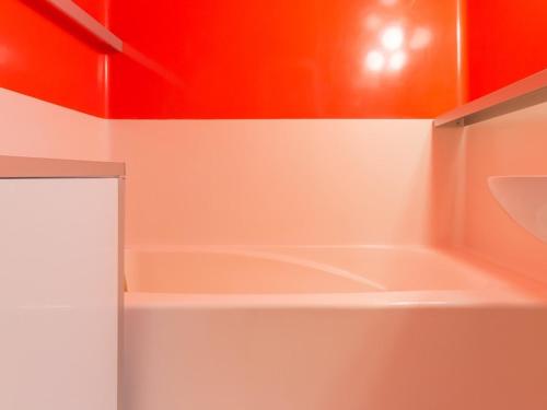 a bathroom with a bath tub with red walls at Appartement Les Arcs 1800, 2 pièces, 5 personnes - FR-1-346-427 in Arc 1800