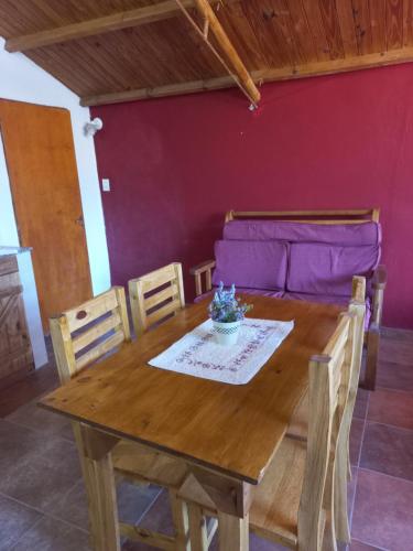 una mesa y sillas en una habitación con una pared púrpura en Depa centro comercial en Villa Pehuenia