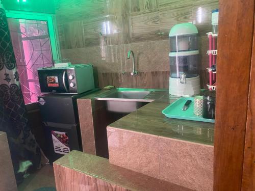 een keuken met een aanrecht met een wastafel en een koffiezetapparaat bij La fierté in Ziguinchor