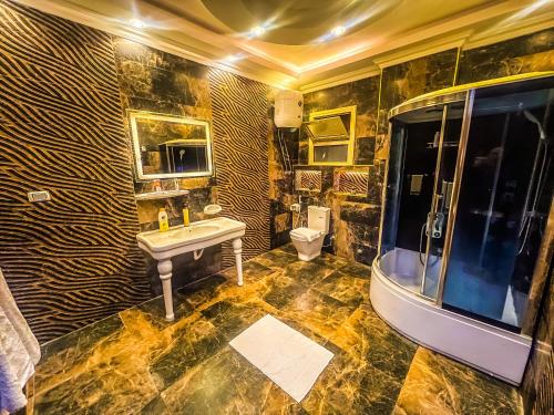een badkamer met een wastafel, een bad en een toilet bij Purity Pyramids View Palace in Caïro