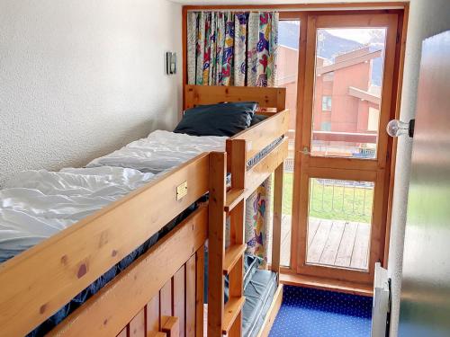 une chambre avec deux lits superposés et une fenêtre dans l'établissement Appartement Ski aux Pieds · Balcon Sud/Ouest · Wifi Gratuit · Arc 1800 - FR-1-346-479, à Arc 1800