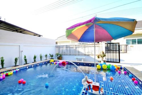 a swimming pool with an umbrella and balls in it at The Guestvilla644 in Hua Hin